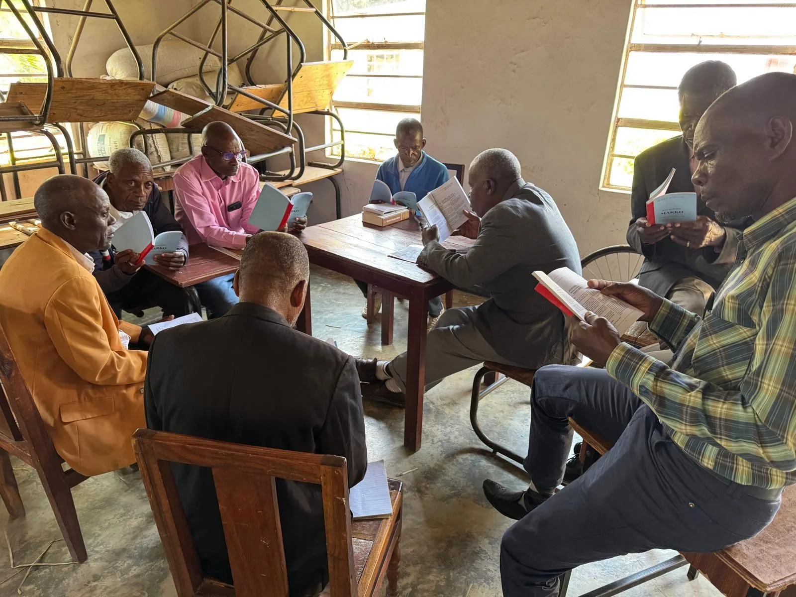 Pastors gathered around a table studying Scripture together at an EPW training